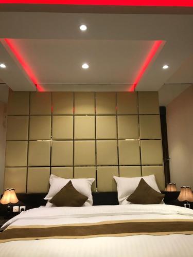 a bedroom with a large bed with red lights on it at Ertiaad Tabuk for Hotel Apartment in Tabuk