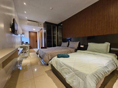 a hotel room with two beds and a kitchen at Apartemen Nagoya Thamrin Tower B lvl 12 Free Netflix in Nagoya