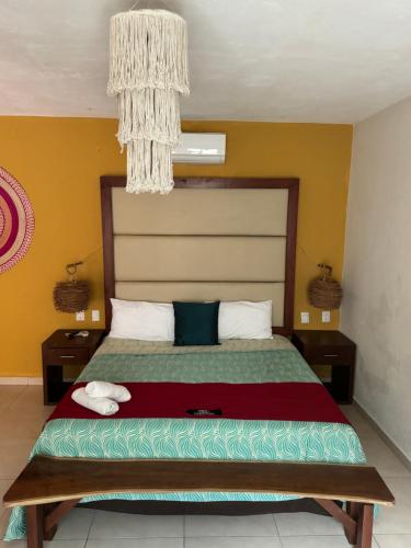 a bedroom with a large bed with a chandelier at Suites Valentina in Puerto Morelos