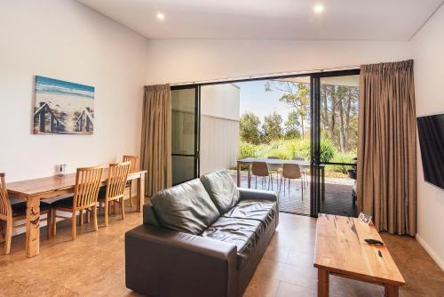 a living room with a couch and a wooden table at Eight Willows Retreat in Margaret River Town