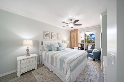 a white bedroom with a bed and a ceiling fan at Gulfside 210 - 2BR plus bunkroom with Ocean & Pool Views in Fort Walton Beach