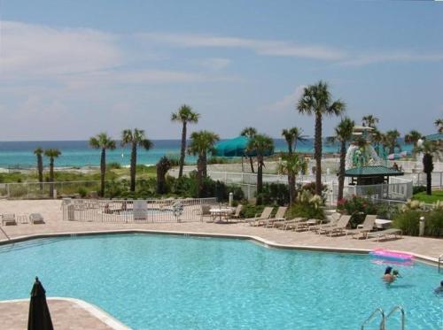 a large swimming pool with chairs and a beach at Destin West Gulfside 209 - You Own Slice of Paradise! - Ocean Views - Free Beach Service! in Fort Walton Beach