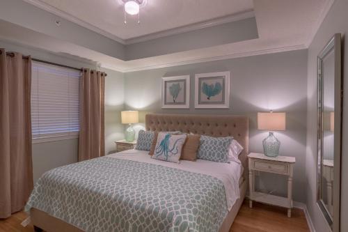 a bedroom with a bed and two lamps and a window at Destin West Gulfside 209 - You Own Slice of Paradise! - Ocean Views - Free Beach Service! in Fort Walton Beach