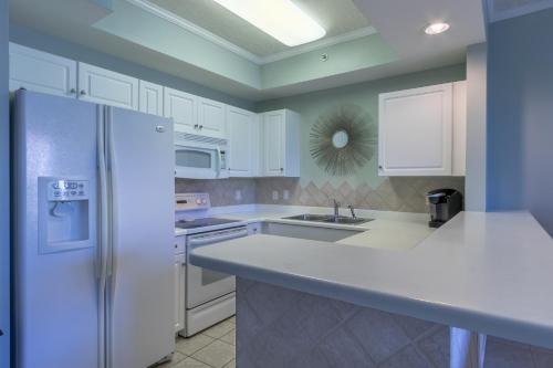 a kitchen with white appliances and a white refrigerator at Destin West Gulfside 209 - You Own Slice of Paradise! - Ocean Views - Free Beach Service! in Fort Walton Beach