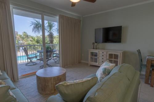 a living room with a couch and a television and a table at Destin West Gulfside 209 - You Own Slice of Paradise! - Ocean Views - Free Beach Service! in Fort Walton Beach