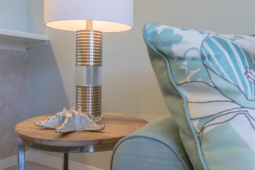 a lamp on a table next to a chair at Destin West Gulfside 209 - You Own Slice of Paradise! - Ocean Views - Free Beach Service! in Fort Walton Beach