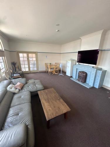 uma sala de estar com um sofá e uma mesa em Coffs Harbour Hotel em Coffs Harbour