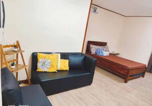 a living room with a couch and a bed at Cozy Condo near Burnham in Baguio