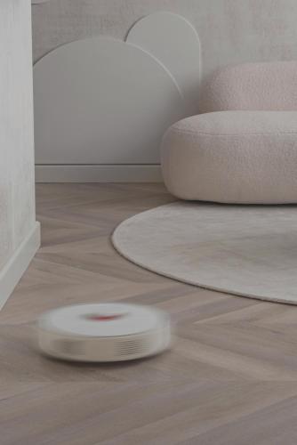 a white frisbee on the floor in a living room at Danės23 - CANDY studio, Self Check-in, Free Parking, Park and River View, Oldtown, A/C in Klaipėda