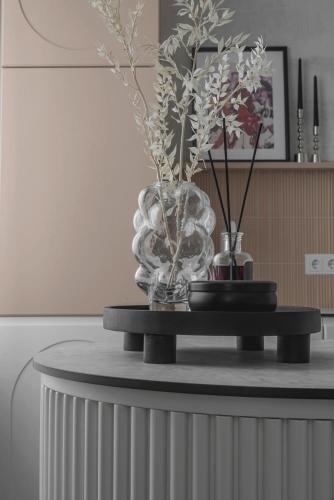 a table with two vases and flowers on it at Danės23 - CANDY studio, Self Check-in, Free Parking, Park and River View, Oldtown, A/C in Klaipėda