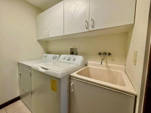 una pequeña cocina con lavadora y fregadero en Ocean view apartment at Las Vistas Nativa Resort, en Puntarenas