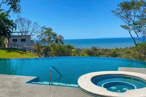 a swimming pool with a jacuzzi tub next to the ocean at Ocean view apartment at Las Vistas Nativa Resort in Puntarenas