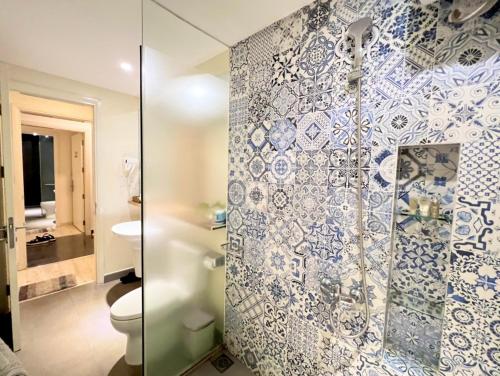 uma casa de banho com um WC e uma cabina de duche em vidro. em Lovely Lady Villa Oceanami Resort, Vung Tau em Long Hai