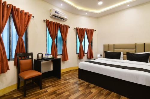 een hotelkamer met een bed en een stoel bij OYO Hotel sakina in Calcutta