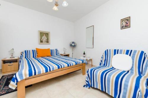 1 Schlafzimmer mit 2 Betten mit blauen und weißen Streifen in der Unterkunft Rooms Miho - close to the sea in Vrboska