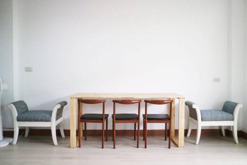 a wooden table with four chairs around it at Happyhouse Laksi station (PK14) in Lak Si