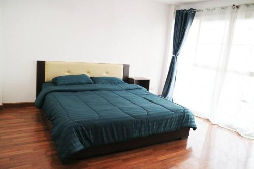 a bedroom with a bed with a blue comforter at Happyhouse Laksi station (PK14) in Lak Si