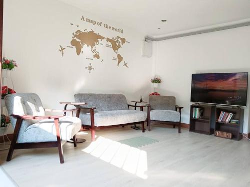 a living room with a map of the world on the wall at Happyhouse Laksi station (PK14) in Lak Si