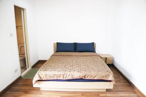 a bedroom with a bed with a blue pillow at Happyhouse Laksi station (PK14) in Lak Si