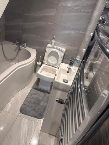 a small bathroom with a toilet and a bath tub at Paradise Vuze in Tilehurst