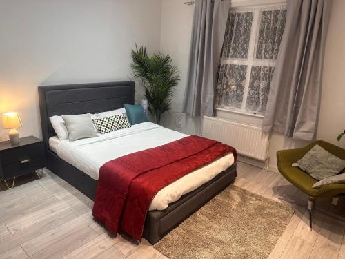a bedroom with a bed with a red blanket at Paradise Vuze in Tilehurst