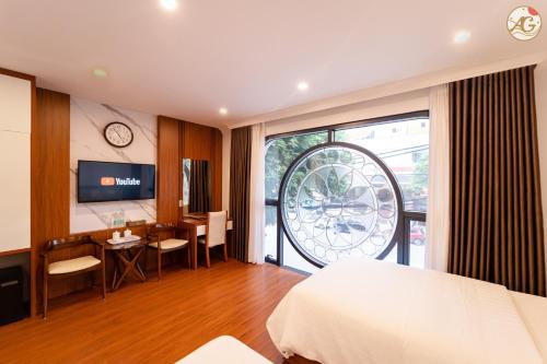 ein Hotelzimmer mit einem Bett, einem Schreibtisch und einem Tisch in der Unterkunft Tamundi Cao Bằng- An Gia Hotel- City Center in Hoàng Ngà