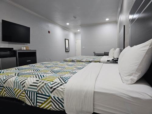 a hotel room with two beds and a flat screen tv at Motel 6 Houston, TX - Hwy 249 and Fallbrook in Houston