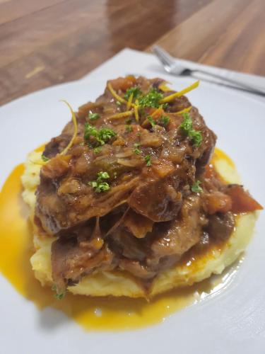 a plate of food with meat on top of mashed potatoes at Manarra Sea View Resort in Puerto Galera