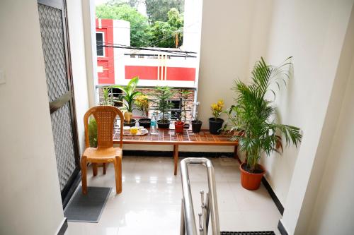 a balcony with a table and potted plants at Shree Home Stay in Ujjain