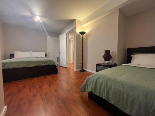 una camera con 2 letti e un pavimento in legno di Spacious 2 bedroom suite a Port Coquitlam