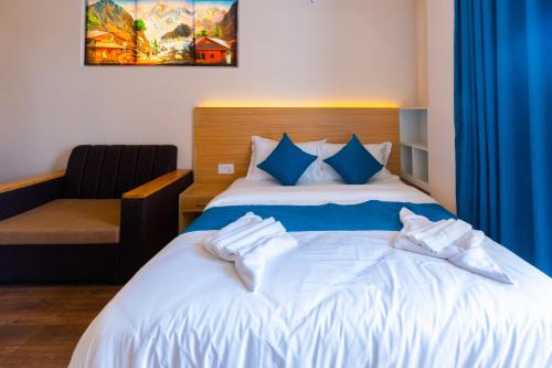 a bedroom with a bed with blue and white sheets at POKHARA APARTMENTS INN in Pokhara