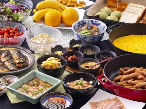 APA Hotel STAY Toyama في توياما: طاولة مليئة بالأطباق بأنواع مختلفة من الطعام