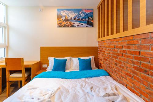 a bedroom with a bed against a brick wall at POKHARA APARTMENTS INN in Pokhara