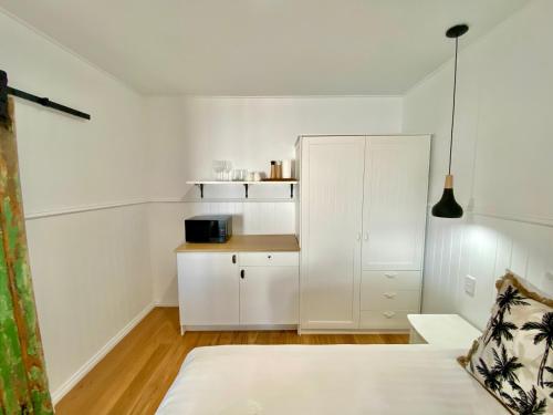 1 dormitorio blanco con 1 cama y armario en Sur Mer Studio - Seaside Escape en Dunsborough