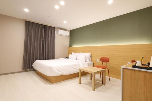 une chambre d'hôtel avec un lit et une table dans l'établissement Calm Rest Hotel Gimhae, à Gimhae