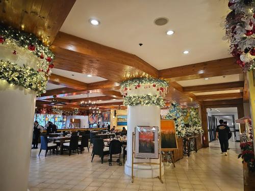 a dining room with tables and chairs and flowers at The Forest Lodge at Camp John Hay privately owned unit with parking 535 in Baguio