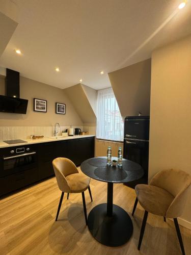 a kitchen with a table and two chairs in a room at Apartamenty Beauty & SPA in Ełk