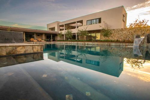 a house with a swimming pool in front of it at Hacienda Las Flores Valle de guadalupe in El Porvenir