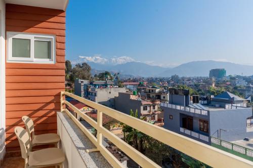 a balcony with chairs and a view of a city at POKHARA APARTMENTS INN in Pokhara