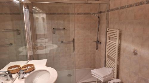 a bathroom with a shower and a sink and a toilet at Hotel Minerva in Pordenone