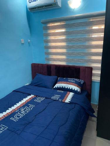 Cama en habitación con paredes azules en Belphus Apartments, en Lagos