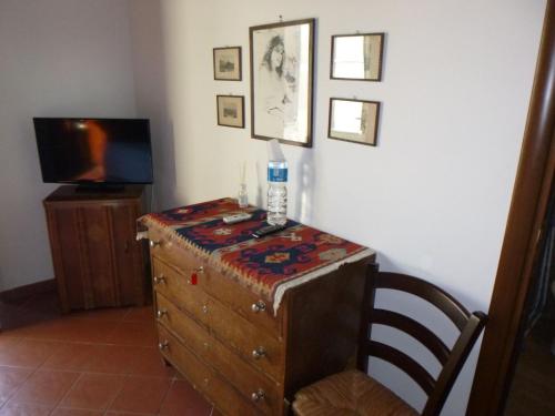 a room with a dresser and a tv on a wall at Baglio Delle Rose in Giarre