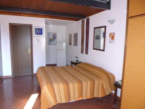 a bedroom with a bed and a refrigerator at Baglio Delle Rose in Giarre