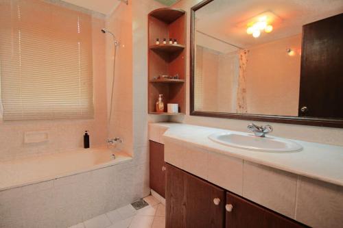 a bathroom with a sink and a tub and a mirror at A Tranquil Retreat Near PWTC & KLCC in Kuala Lumpur