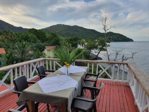 a table and chairs on a deck next to the water at Hotel Sol y Luna in Capurganá