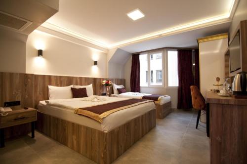 イスタンブールにあるVali Konak Hotelの大型ベッドとテレビが備わるホテルルームです。