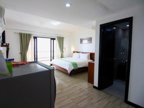 a hotel room with a bed and a large window at Manarra Sea View Resort in Puerto Galera