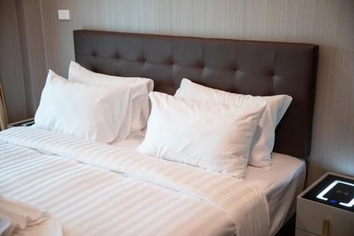 a bed with white sheets and pillows in a room at SeeView Resort (ซีวิว รีสอร์ต) in Ban Pak Nam