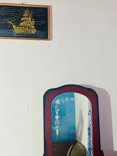 einen Spiegel in einem Zimmer mit einem Bild an der Wand in der Unterkunft Kalanı villa in Kotugoda