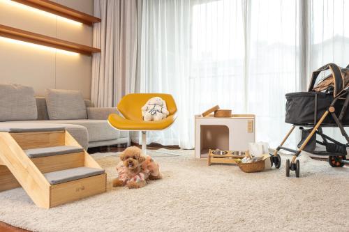 a living room with a couch and a yellow chair at Somerset Jeju Shinhwa World in Seogwipo